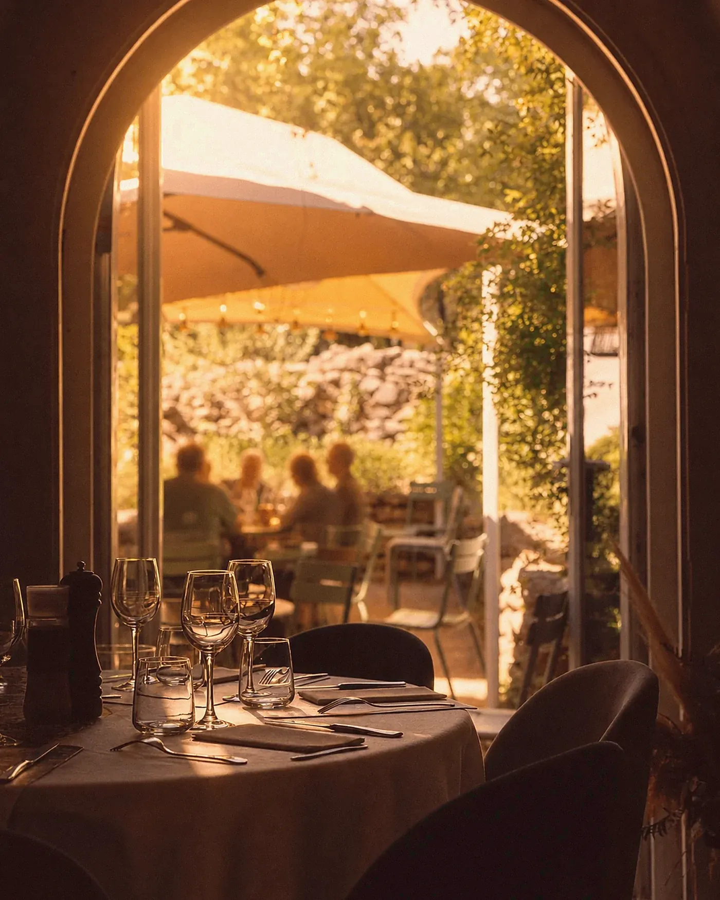 Côté terrasse : table nappée sous les guirlandes, service soigné.